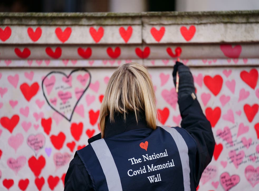 Un voluntario pinta un corazón en el Muro Conmemorativo Nacional del Covid en el centro de Londres, que recuerda a las personas que han muerto a causa del virus;