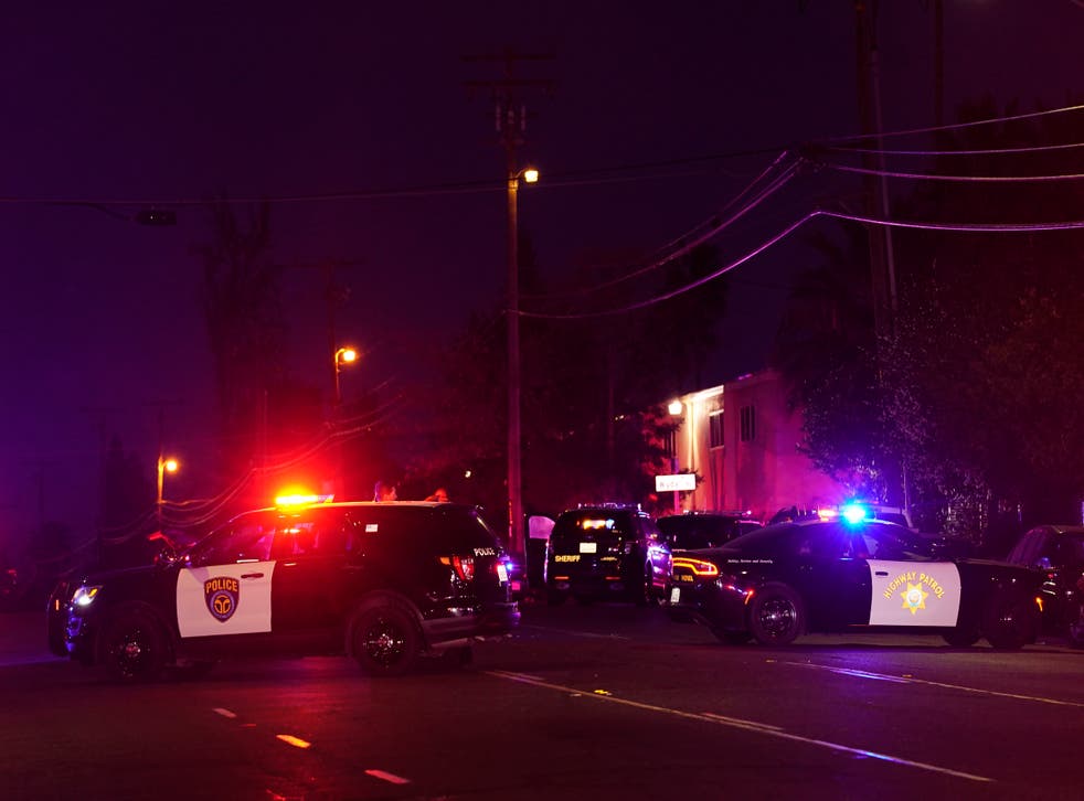 Vehículos de las fuerzas del orden de varios organismos bloquean una calle cerca del lugar de un tiroteo en Sacramento