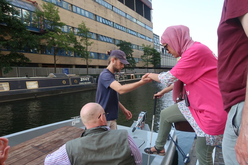 Hombre ayudando a una mujer a subir a la barca